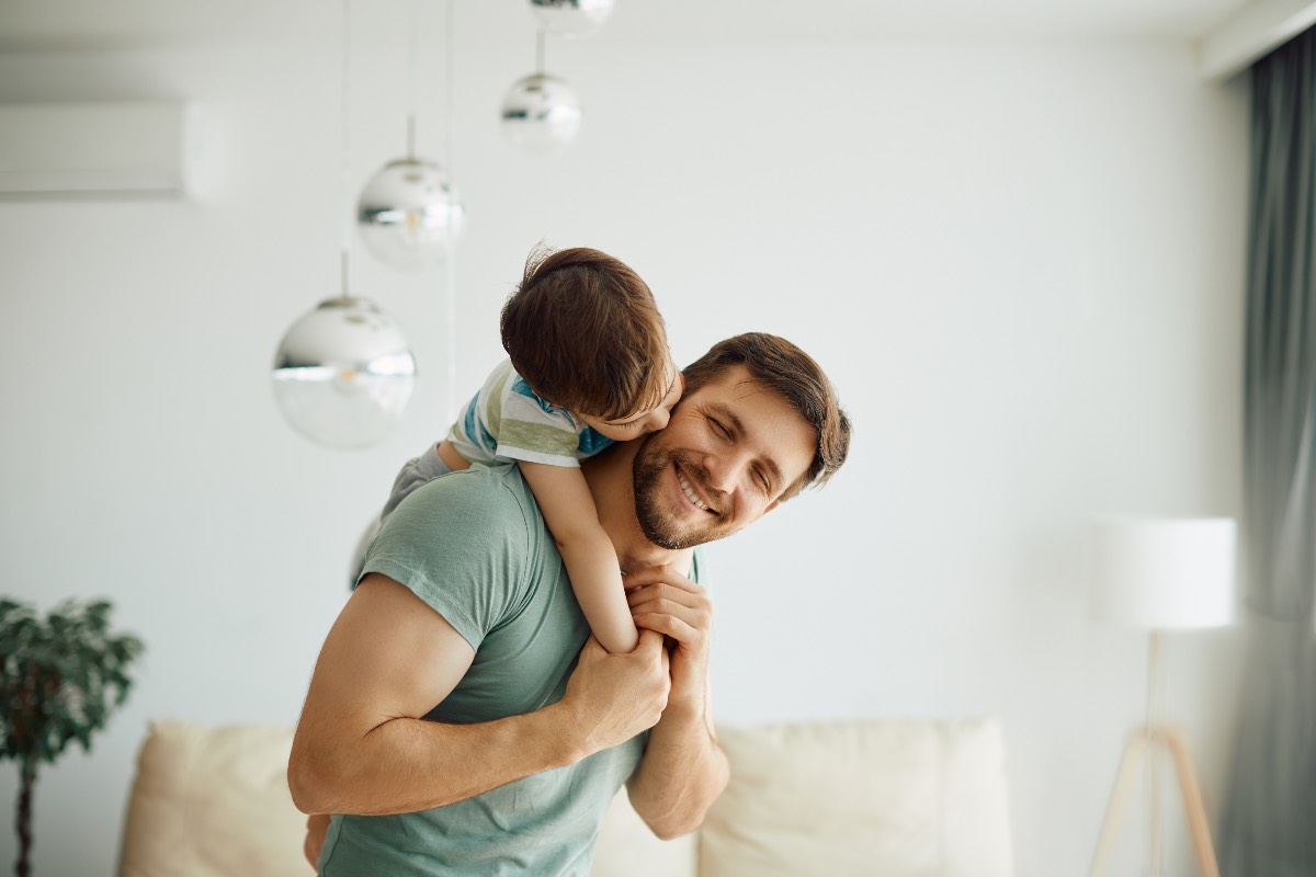 Ein liebevoller Vater trägt seinen kleinen Sohn huckepack.