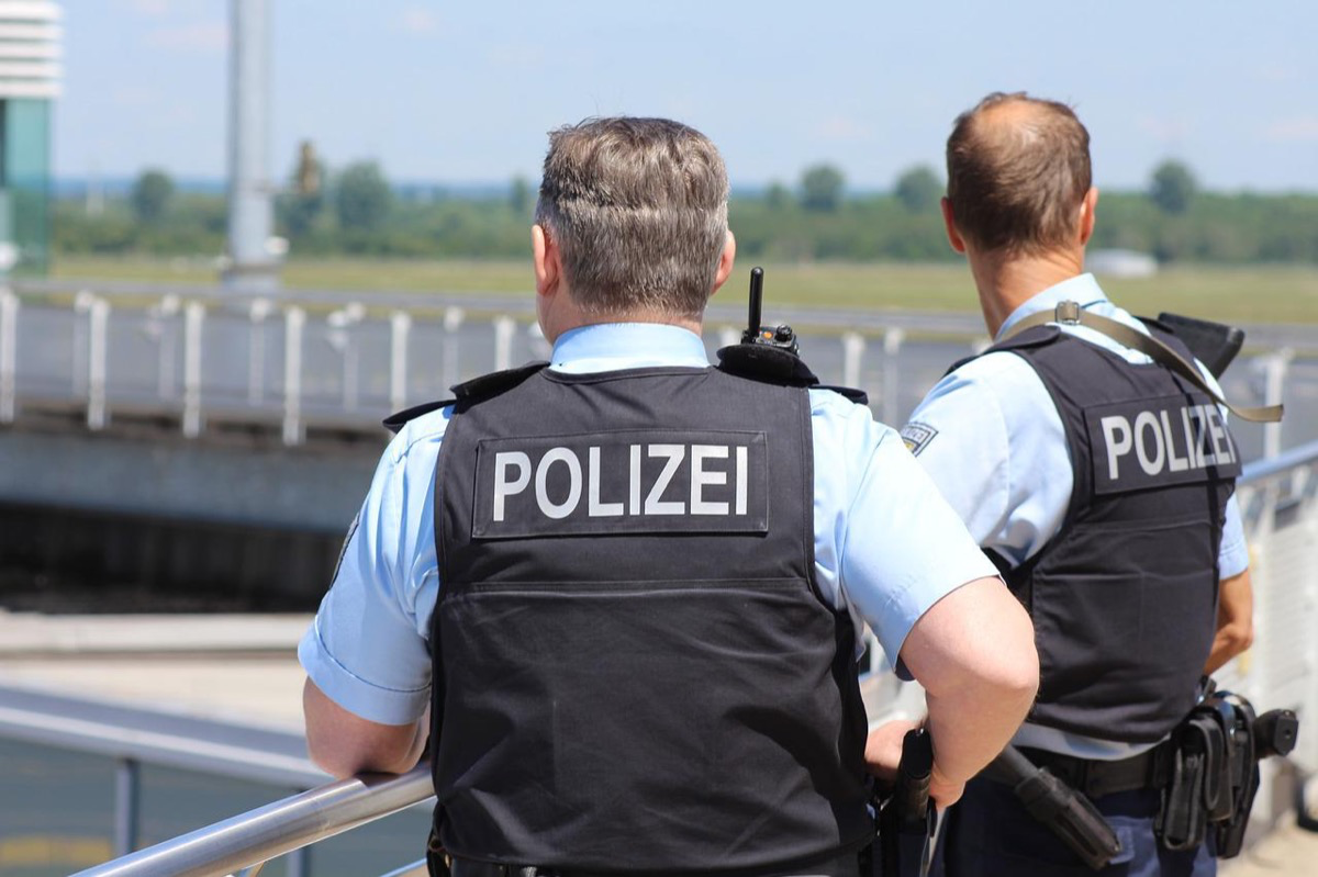 Zwei Polizisten stehen draußen an einem Geländer