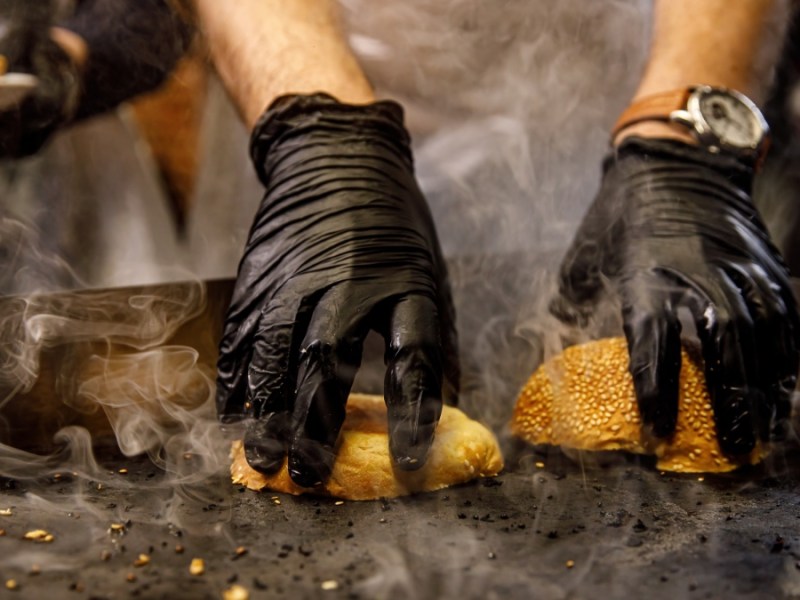 Hamburgerbrötchen, die mit der Vorderseite nach unten auf einem heißen Grill getoastet werden