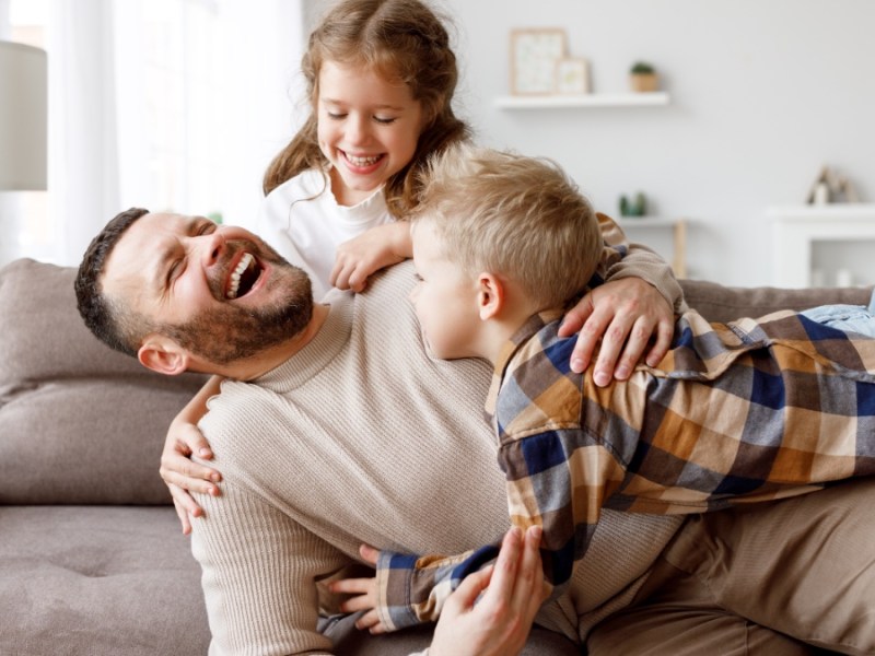 Ein Vater spielt mit seinen Kindern.