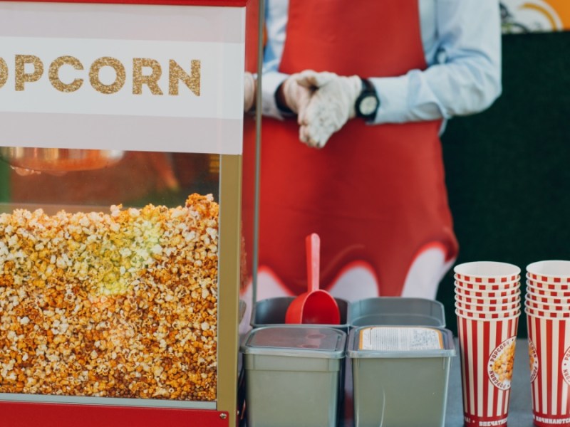 Mann mit Popcornwagen.