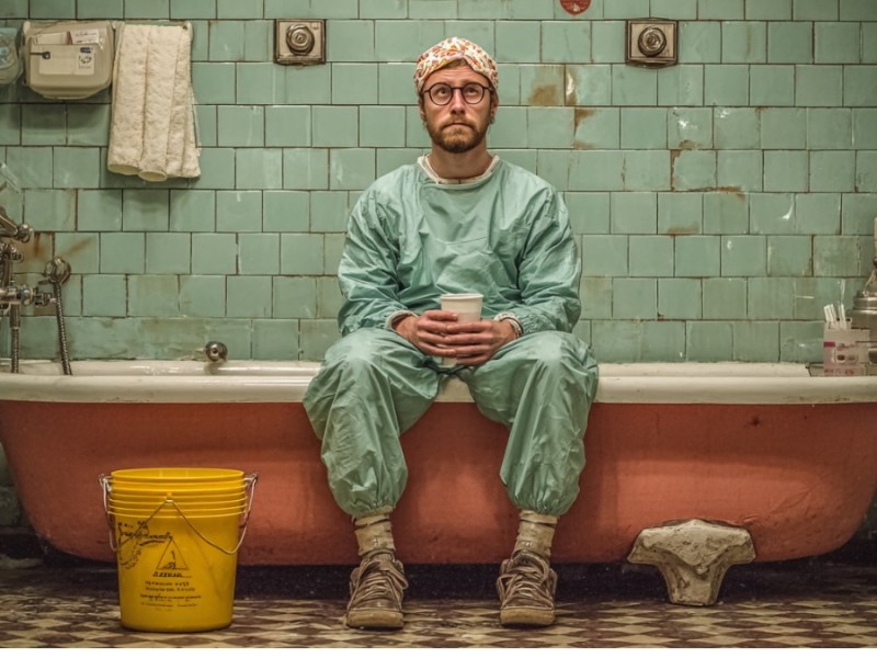 Mann sitzt in Badezimmer. (KI-generiert)